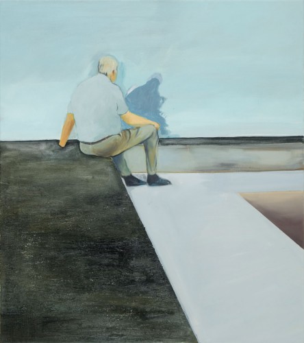 ein alter Mann in graune Hemd sitzt vor einer grauen Wand